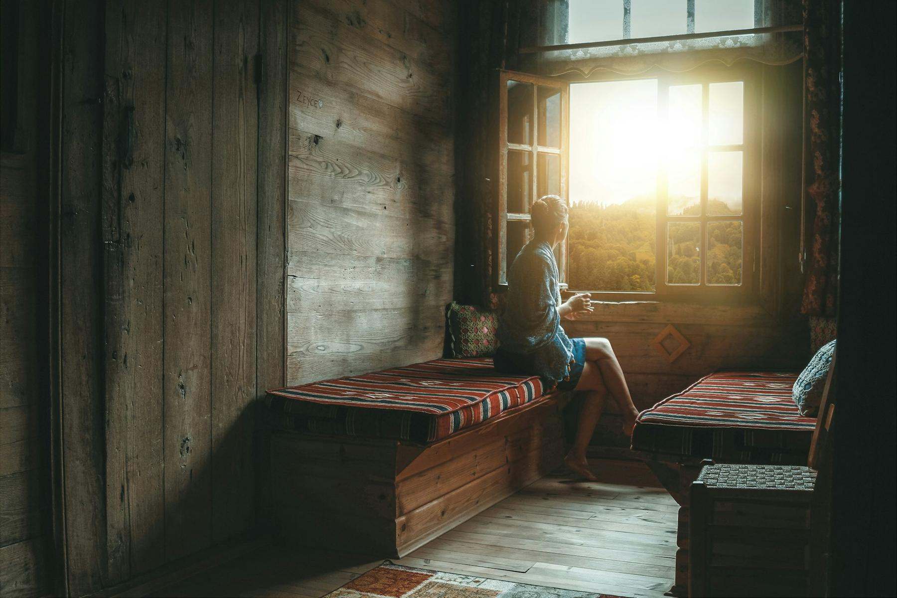 Someone sitting by a window as morning light comes in
