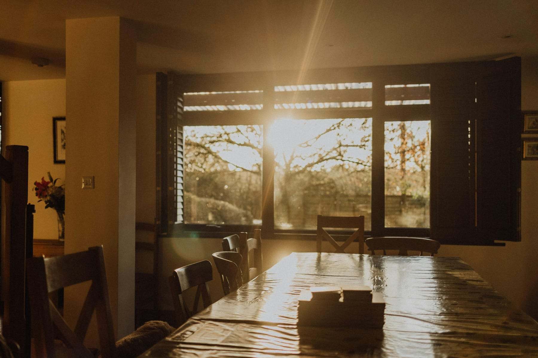 Low sun streaming through a large window onto an empty dining table